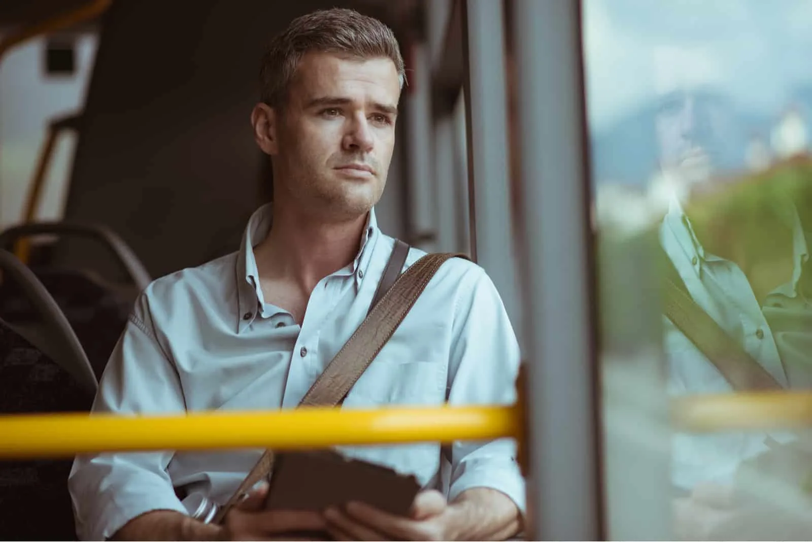 Selbstbewusster nachdenklicher Mann, der im Bus sitzt