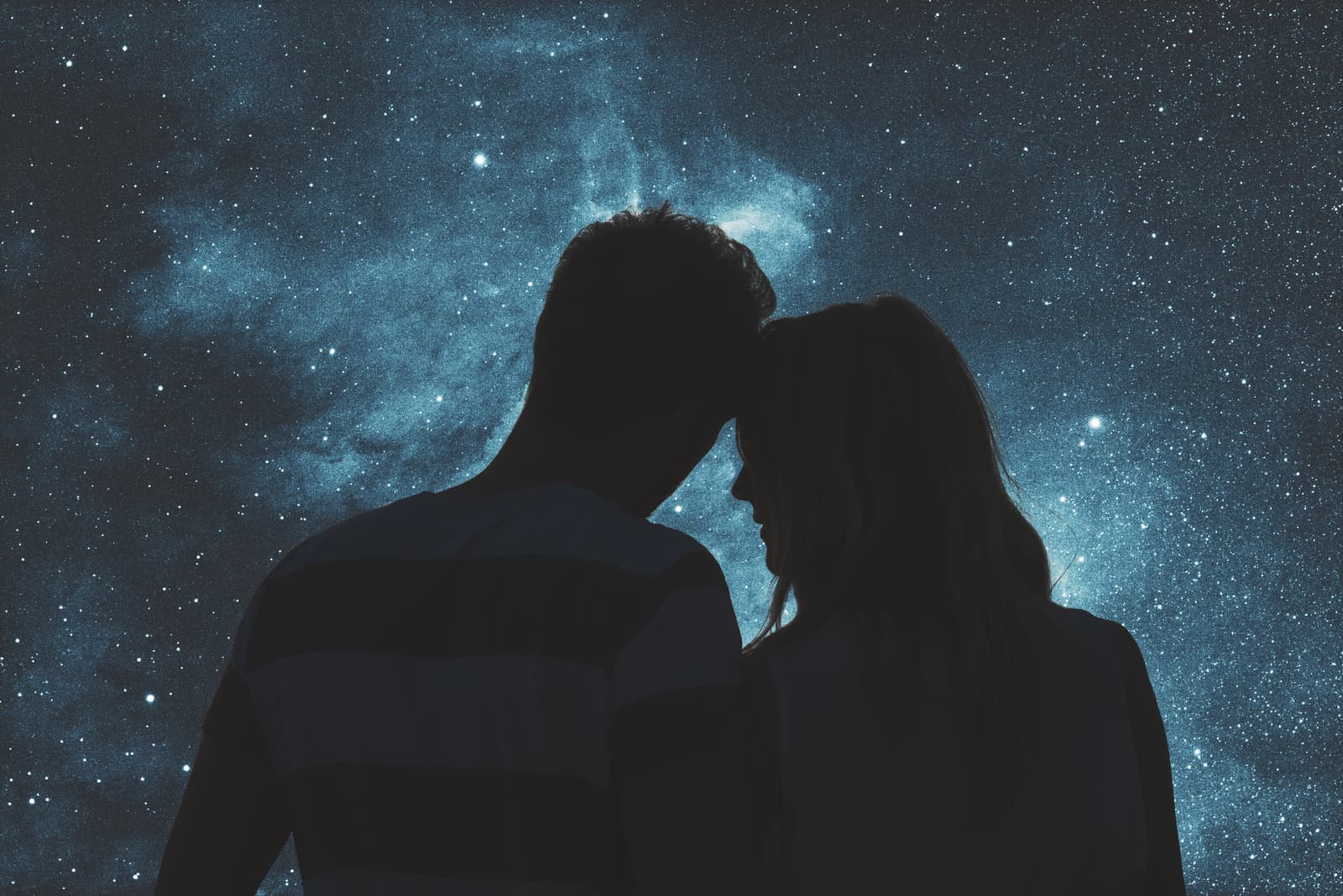 Silhouetten eines jungen Paares unter dem Sternenhimmel