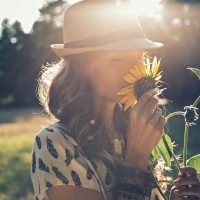 Mädchen riecht Sonnenblume in der Natur