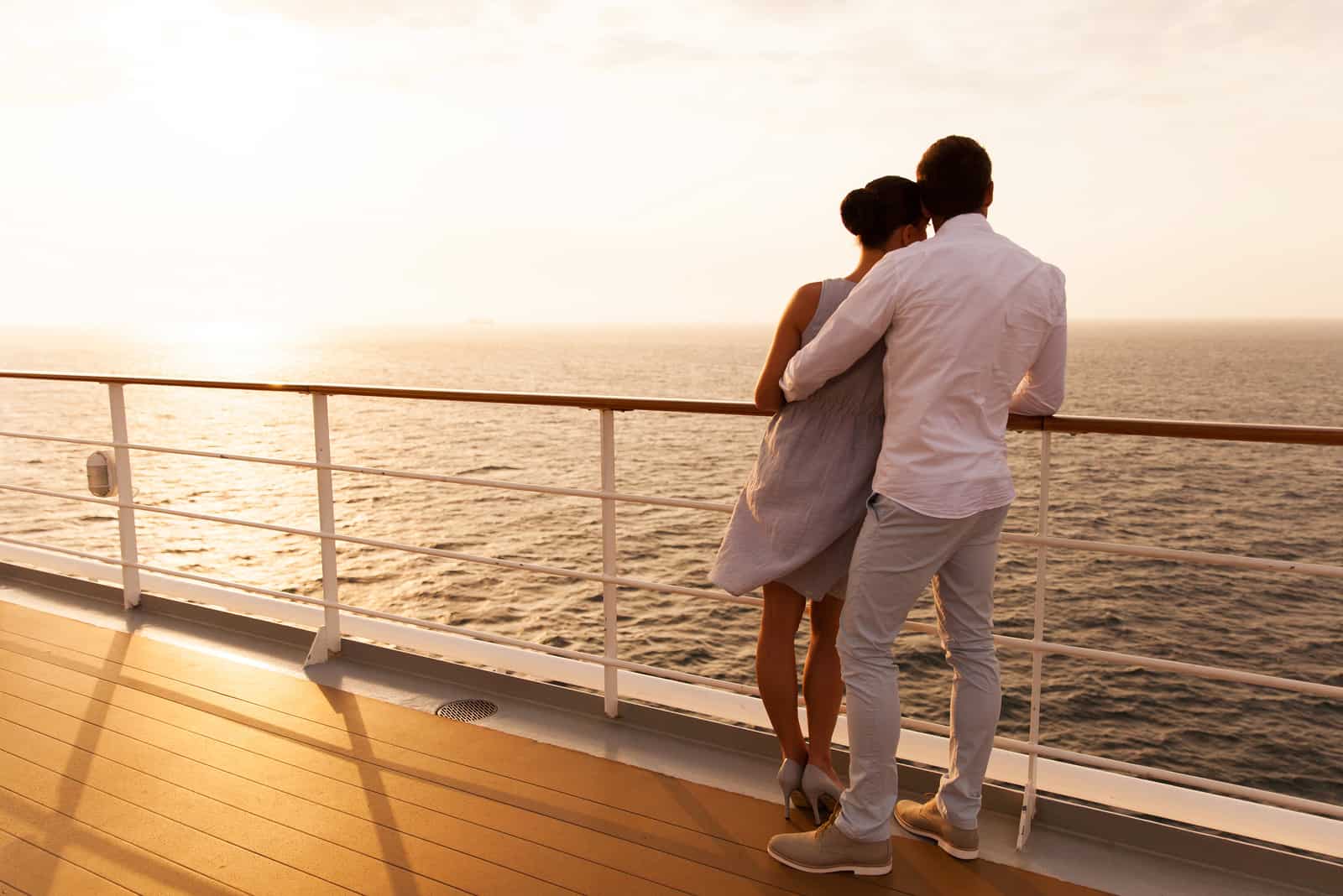 junges Paar, das bei Sonnenuntergang auf Kreuzfahrtschiff umarmt