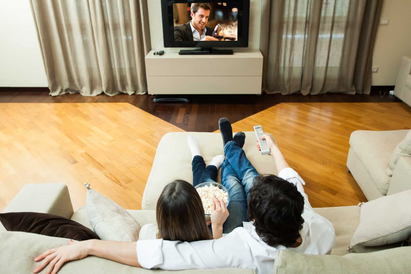 Junges Paar isst Popcorn, während es einen Film sieht
