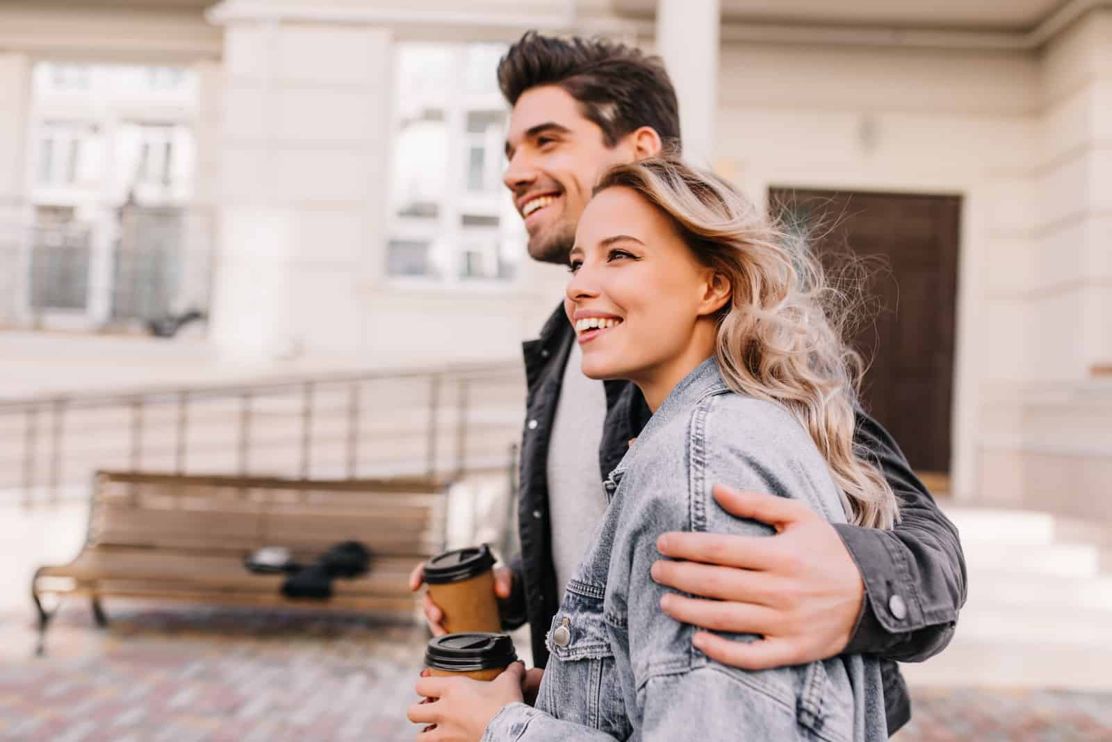 Mädchen trinkt Kaffee beim Spaziergang mit ihrem Freund