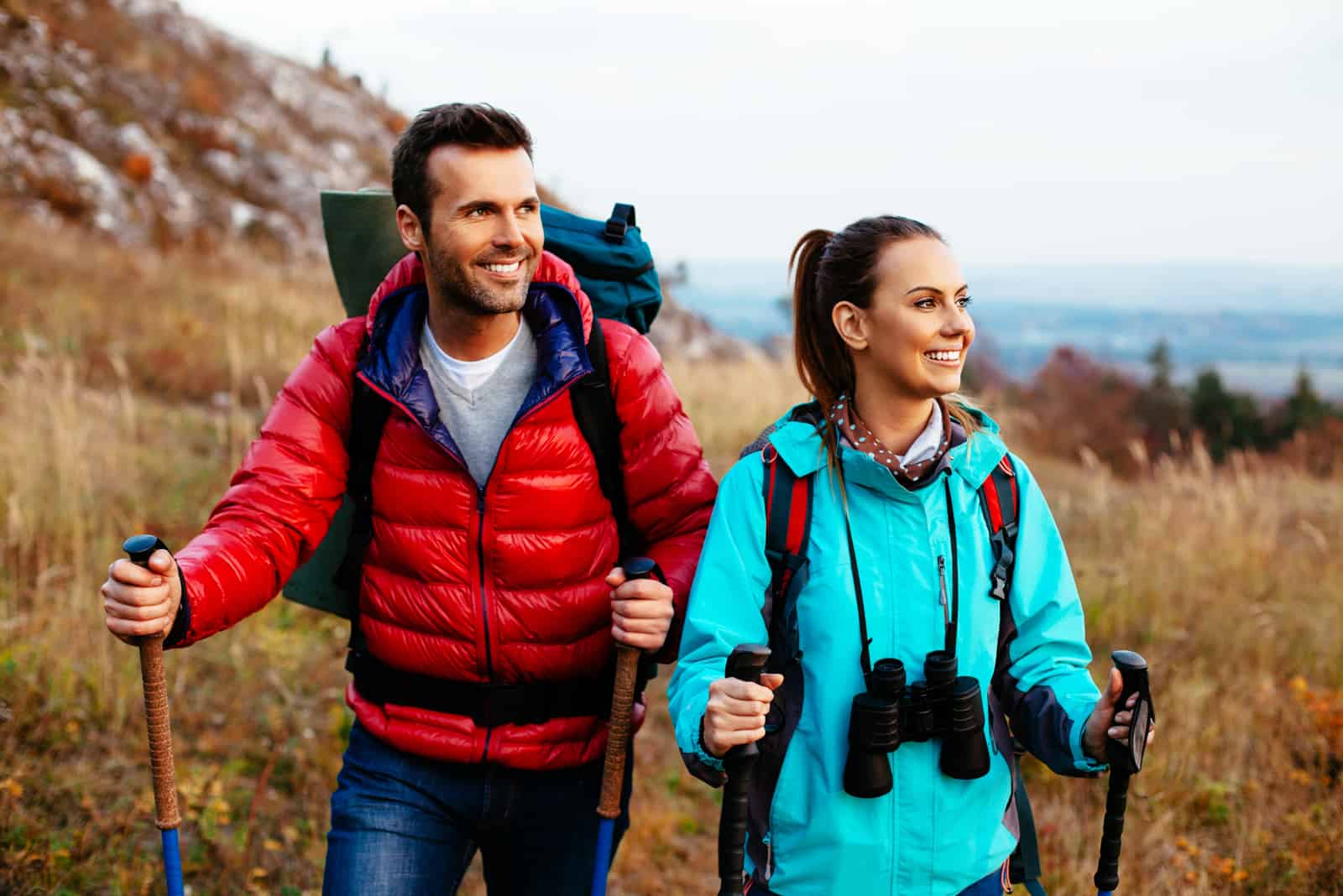 Backpacker-Paar wandert im Herbst mit Stöcken