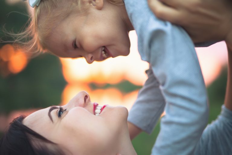 die mutter trägt ihre tochter und sie lachen