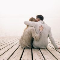 Paar umarmt sich auf einem Pier