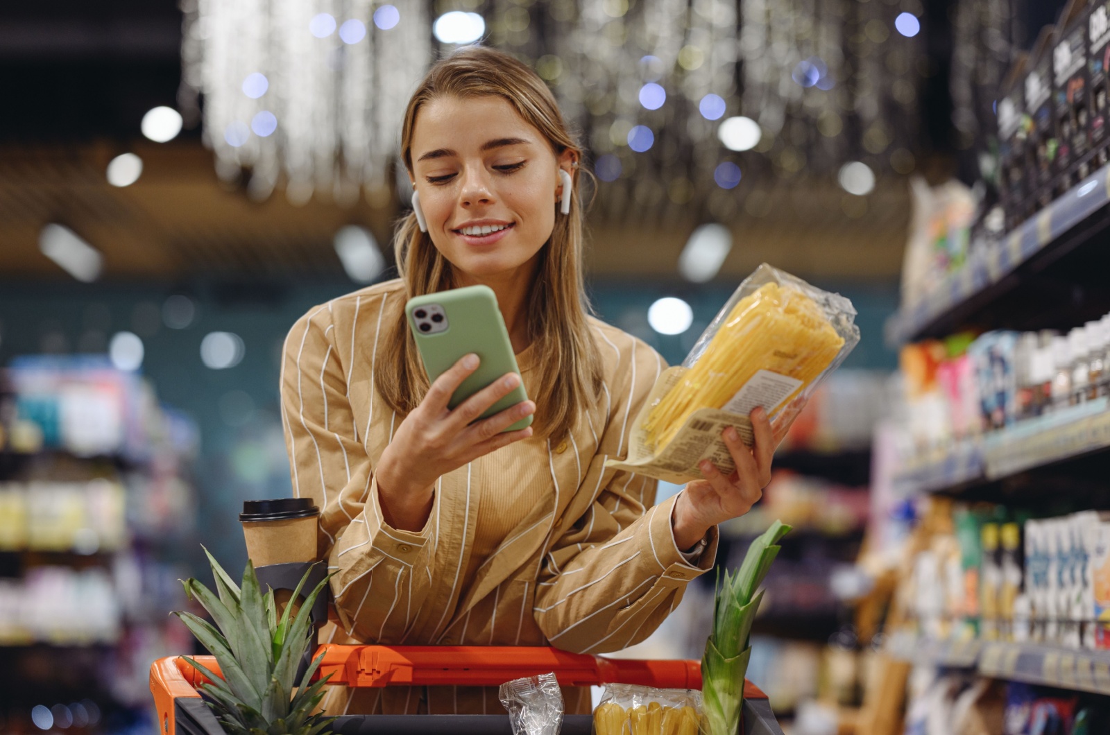 Frau haelt ein Telefon im Markt