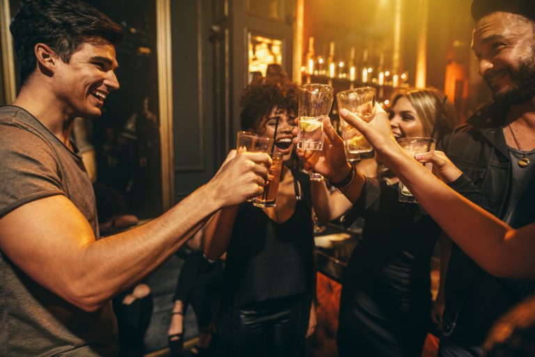 Freunde stoßen mit einem Drink in der Disco an