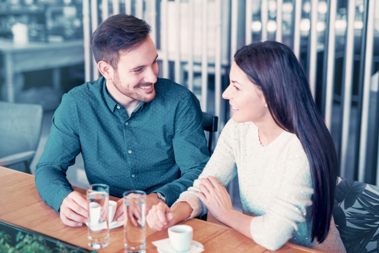 Ein Mann und eine Frau sitzen in einem Café und unterhalten sich beim Kaffee