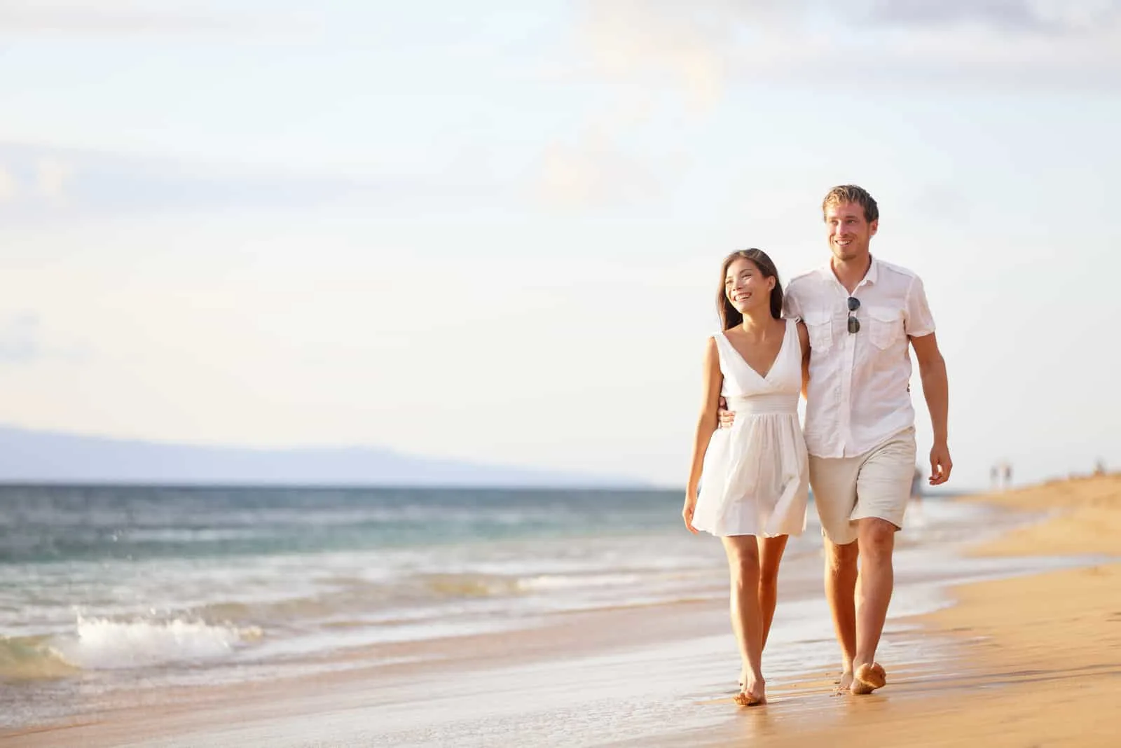 ein Mann und eine Frau gehen am Strand entlang