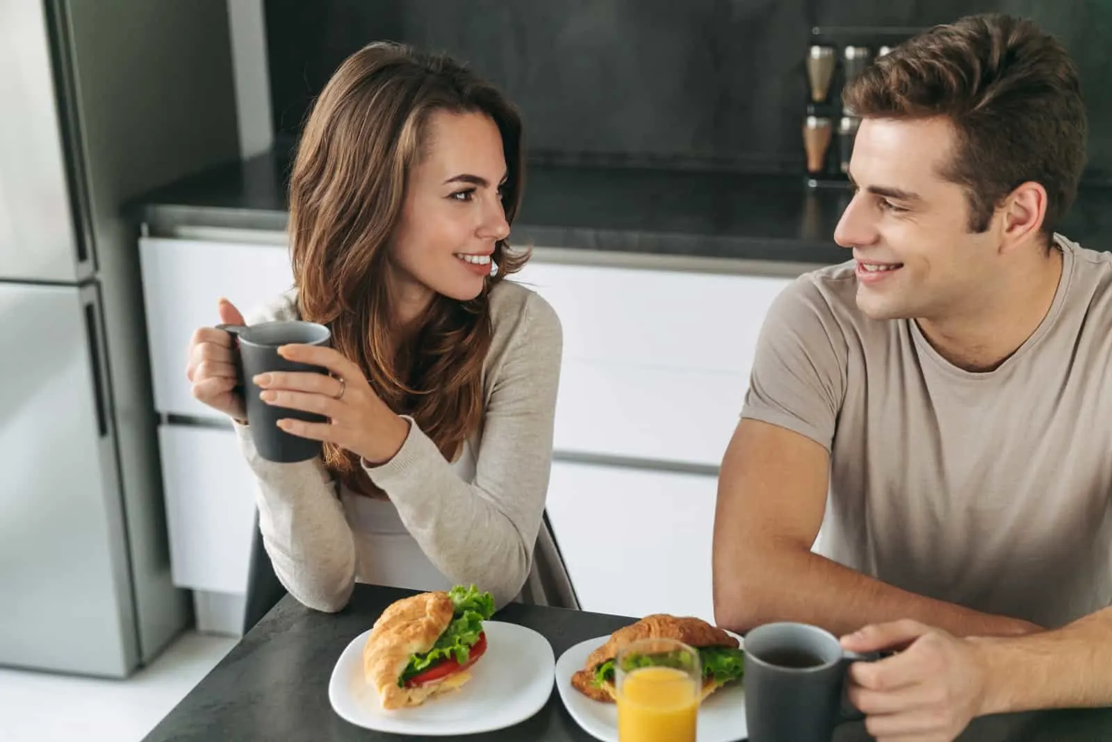 ein Mann und eine Frau sitzen beim Frühstück an einem Tisch und unterhalten sich