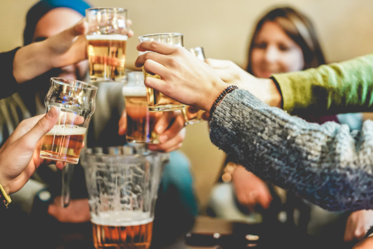 Fröhliche Freunde, die mit Biergläsern jubeln