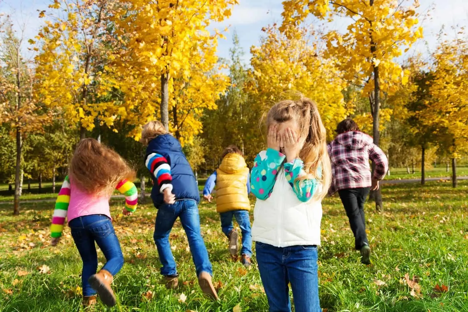 Kinder spielen Verstecken im Herbstpark