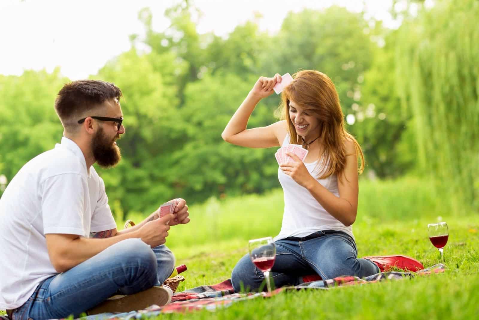 Liebespaar beim Picknick Kartenspiel im Park