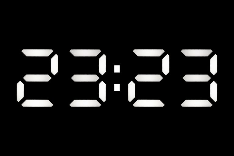 Digitaluhr auf 23:23 Uhr auf schwarzem Hintergrund