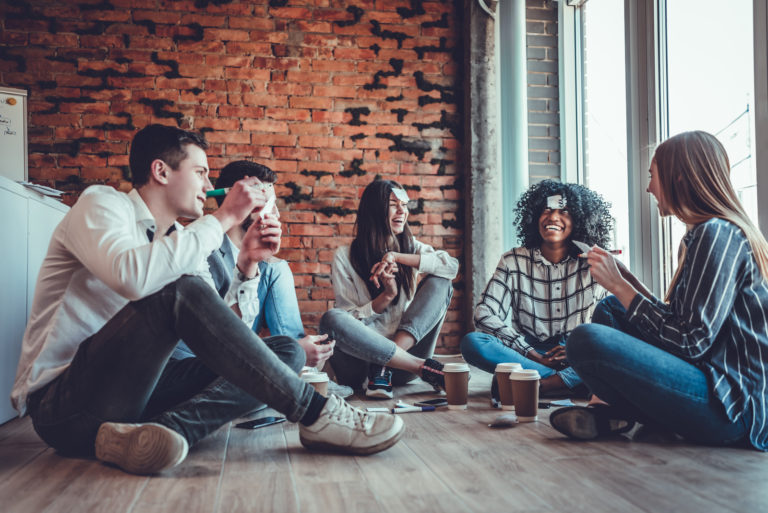 Glückliche Freunde, die Kaffee trinken und ein Spiel spielen