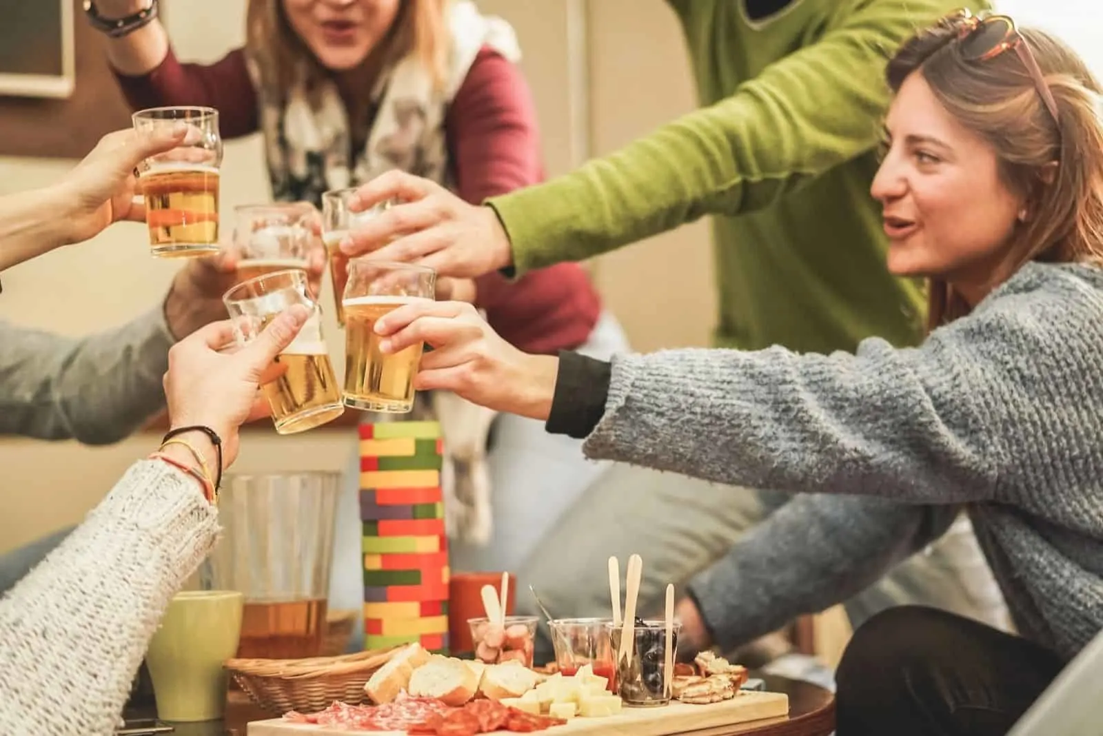 glückliche reiche Freunde Jenga-Spiel mit Bier in einer Brauerei-Chalet-Party spielen