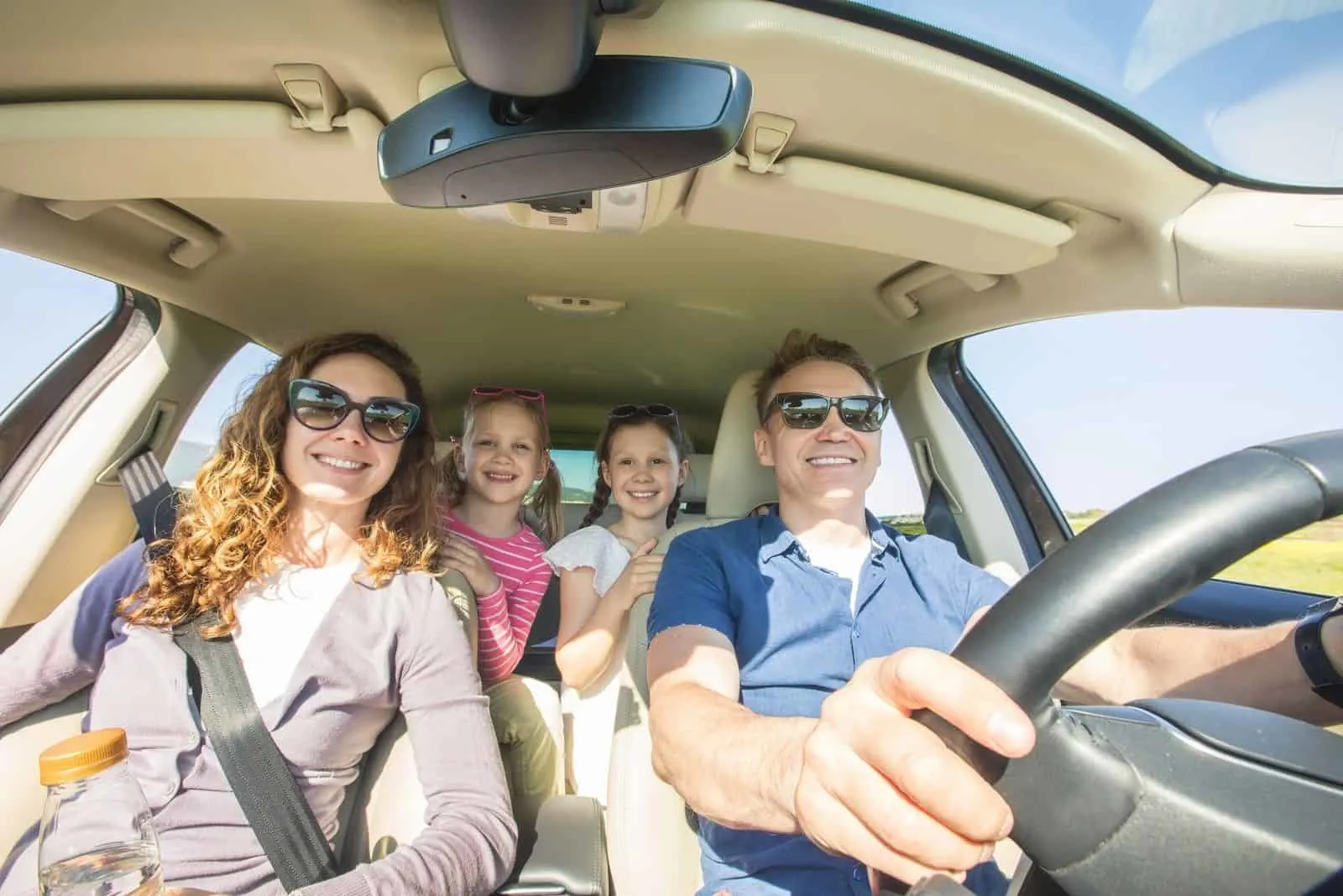 glückliche reisende Familie im Auto bei schönem Wetter