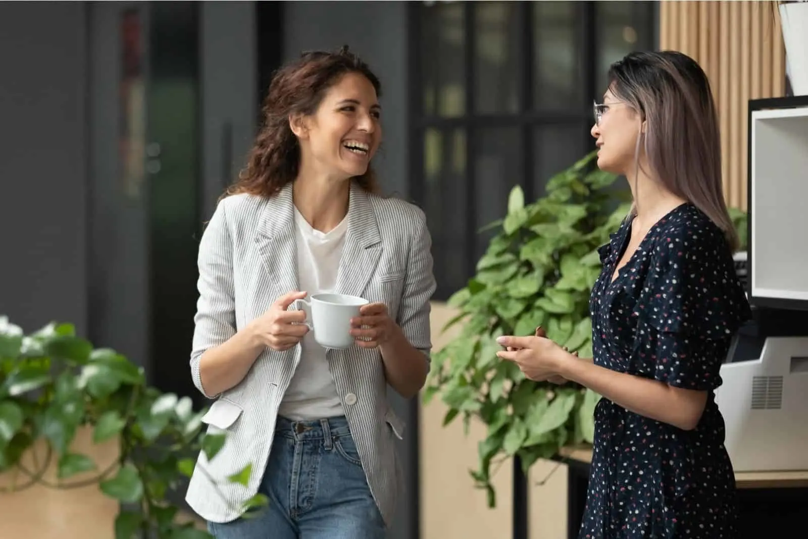 glückliches positives weibliches Lachen und Plaudern während der Kaffeepause