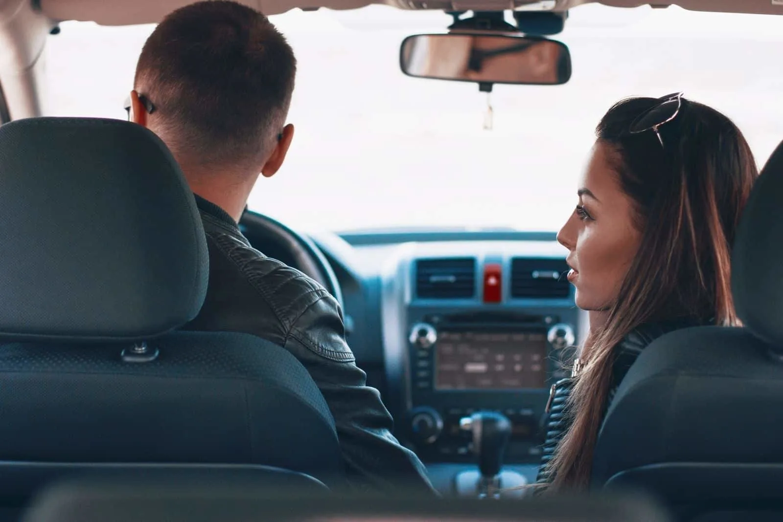 Schönes Paar im Auto redet ernsthaft mit Lederjacke