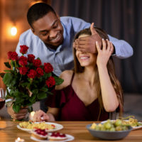 ein Mann überraschte eine Frau mit einem Strauß roter Rosen