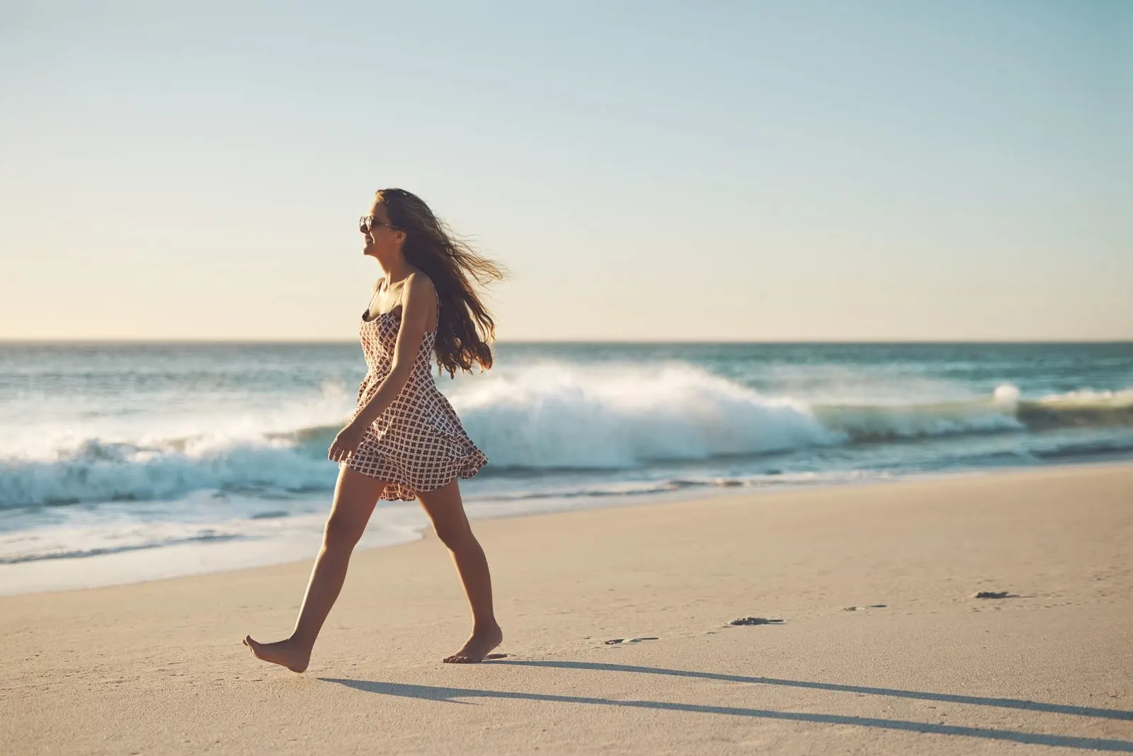 Ein schönes Mädchen geht am Strand spazieren