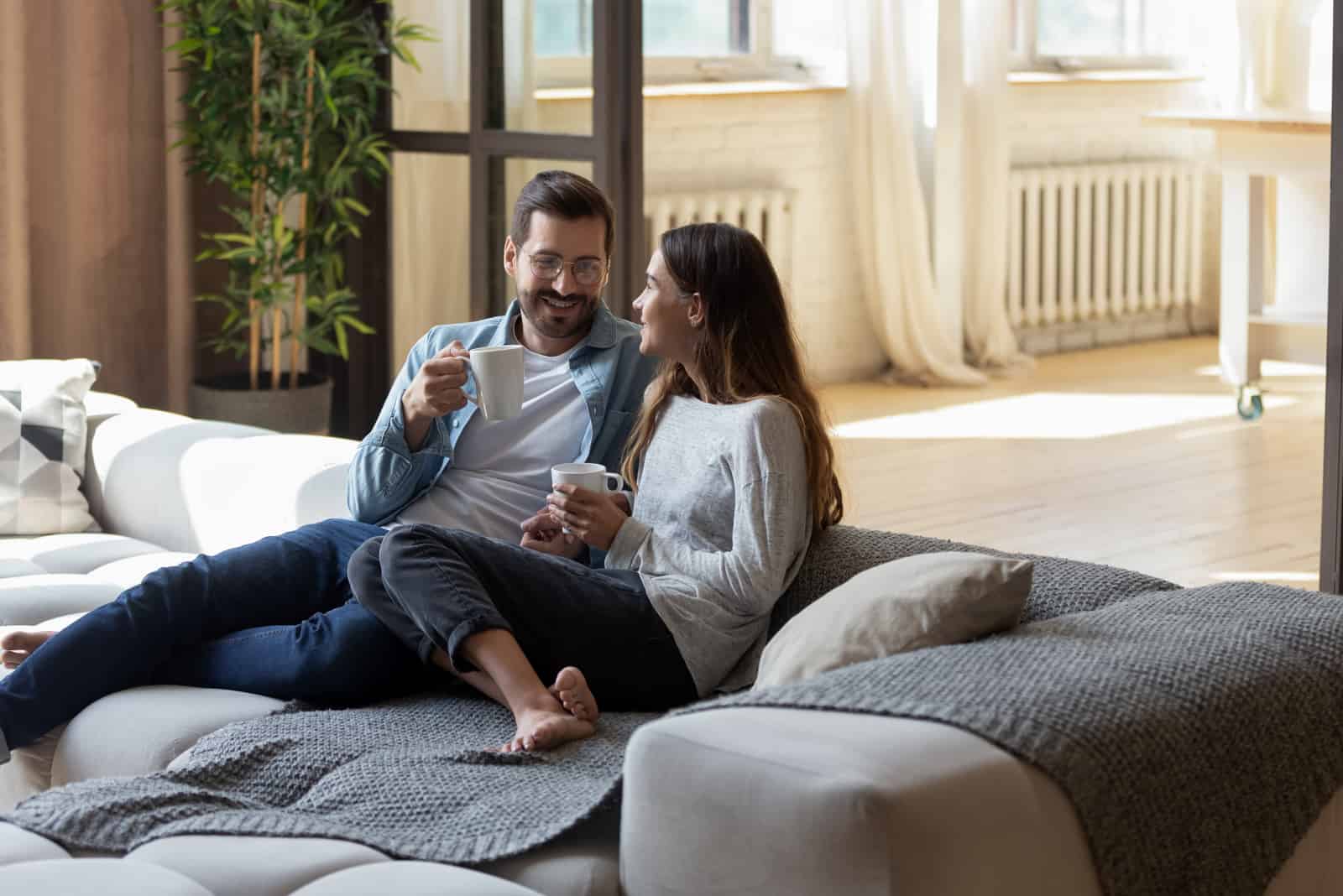 Liebespaar entspannt auf gemütlichem Sofa im Wohnzimmer