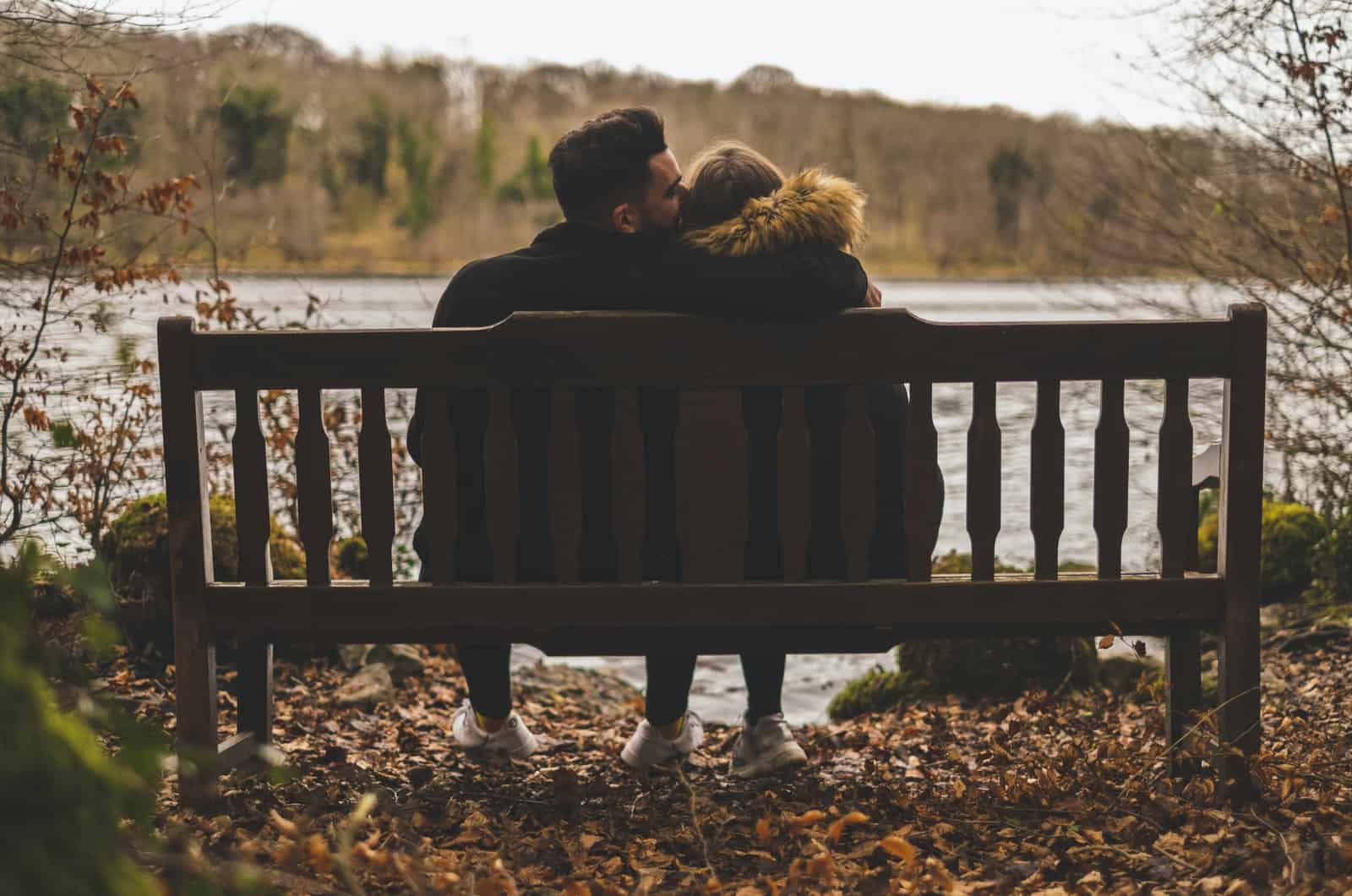 Paar sitzt im Herbst auf einer Bank