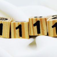 Zahlen 1111 auf Holzsockel geschnitzt
