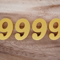 goldene Zahl 9999 auf Holzoberfläche