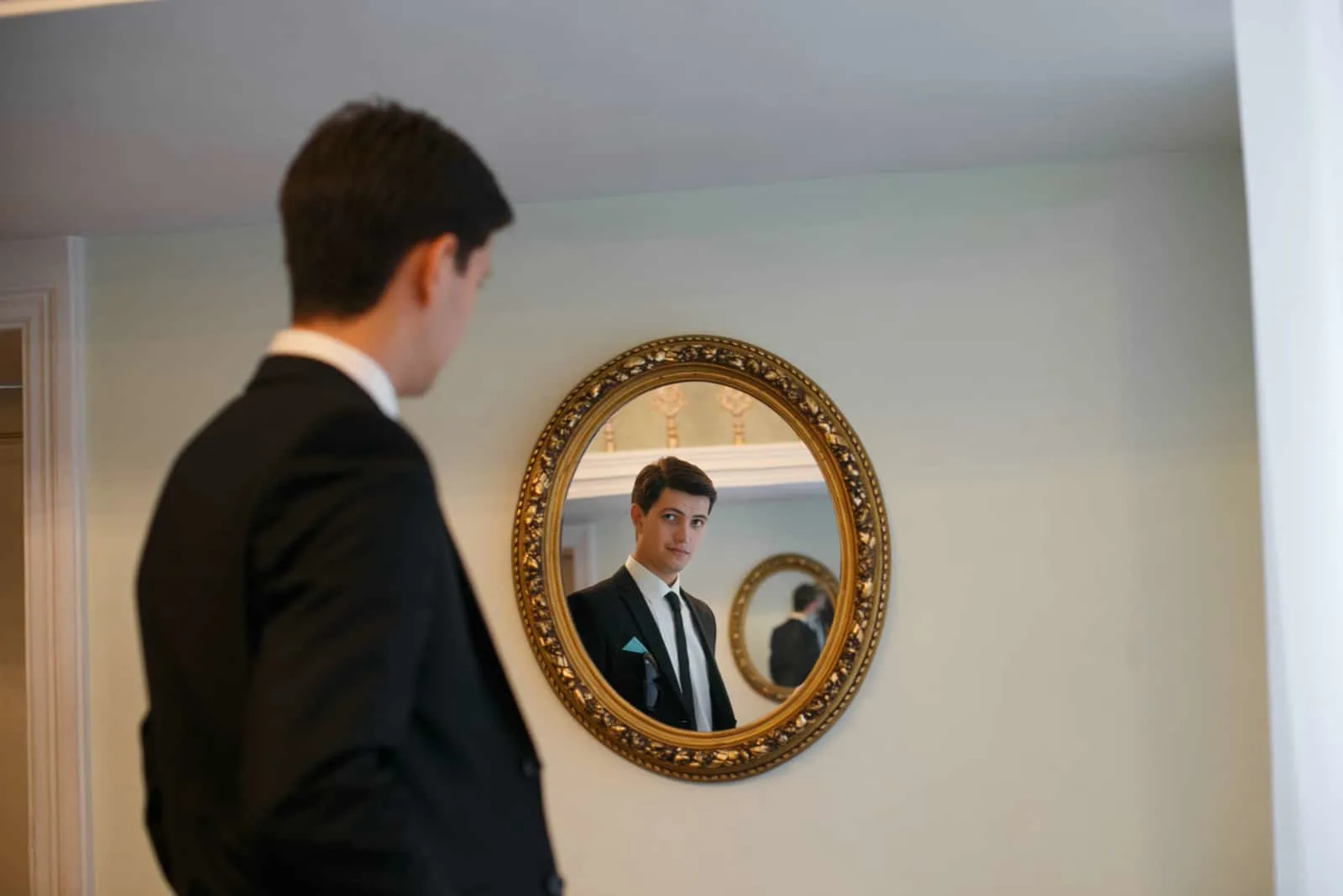 der mann steht und schaut in den spiegel