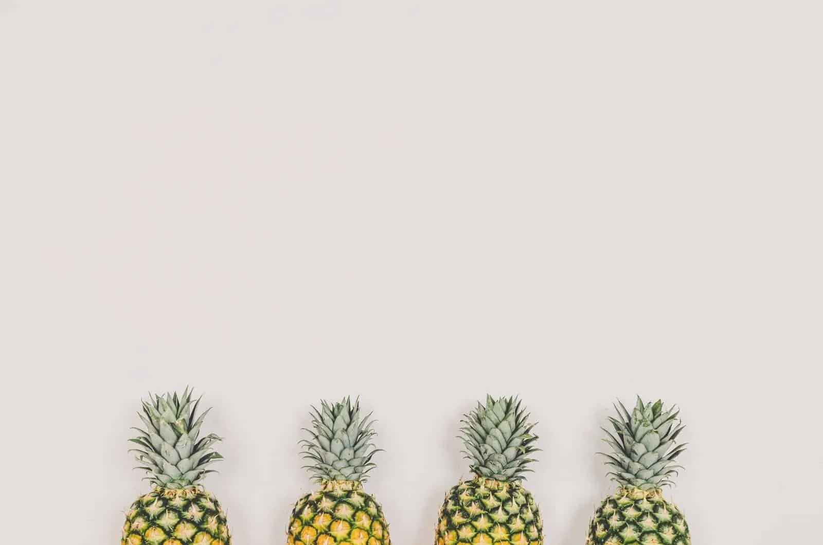 vier Ananas mit grauem Hintergrund