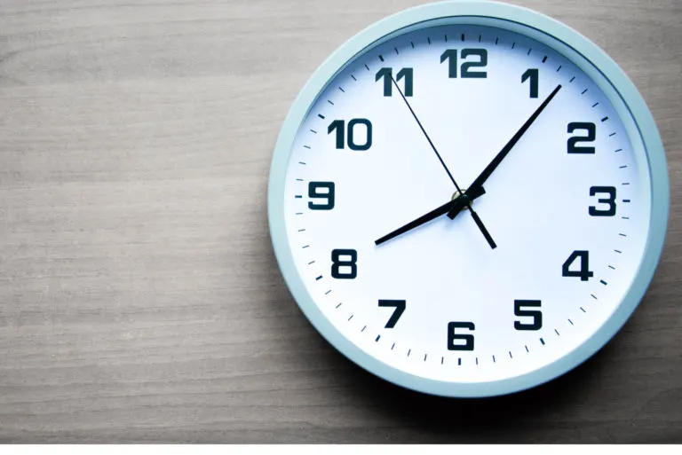 eine weiße uhr steht an der wand