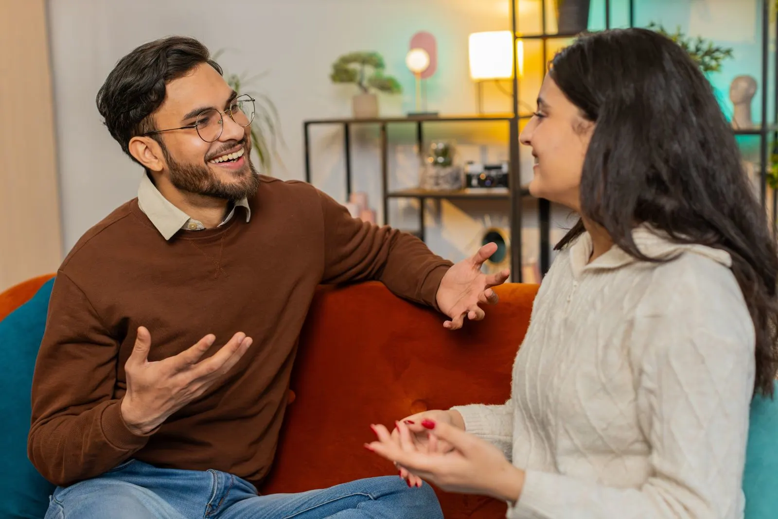 Lächelnder Mann und Frau sitzen auf der Couch und reden