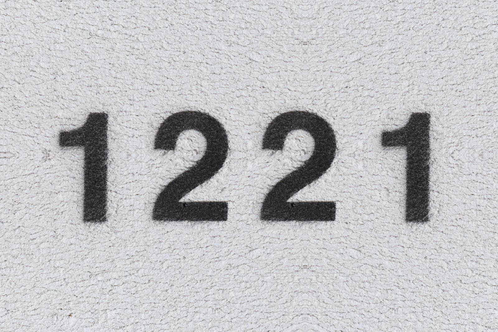 schwarze Nummer 1221 an grauer Wand