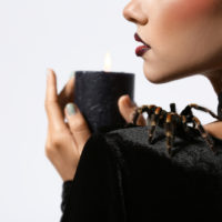 Frau mit einer Spinne auf der Schulter