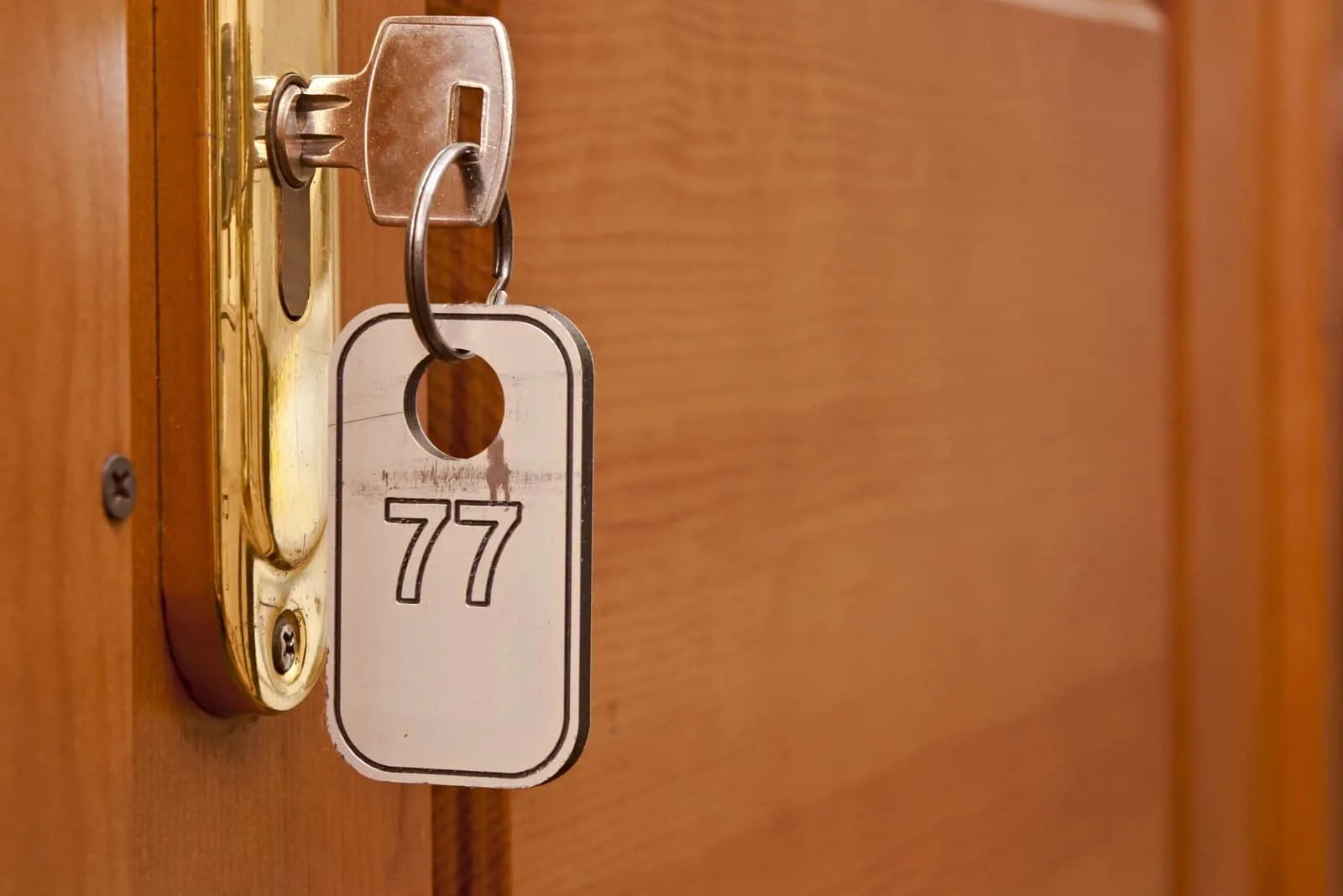 Schlüsselanhänger mit der Nummer 77 im Türschloss