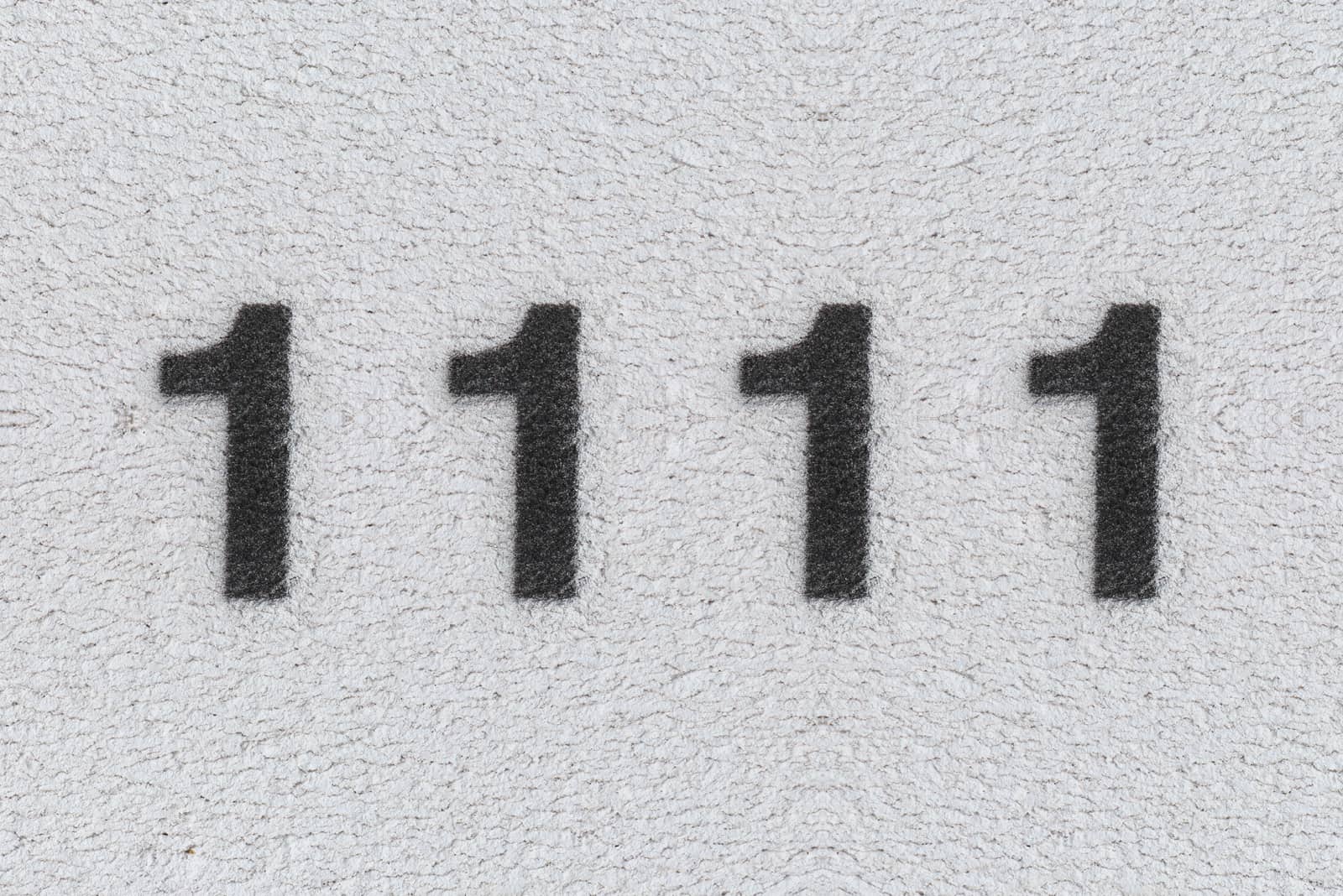 Schwarze Nummer 1111 auf der weißen Wand