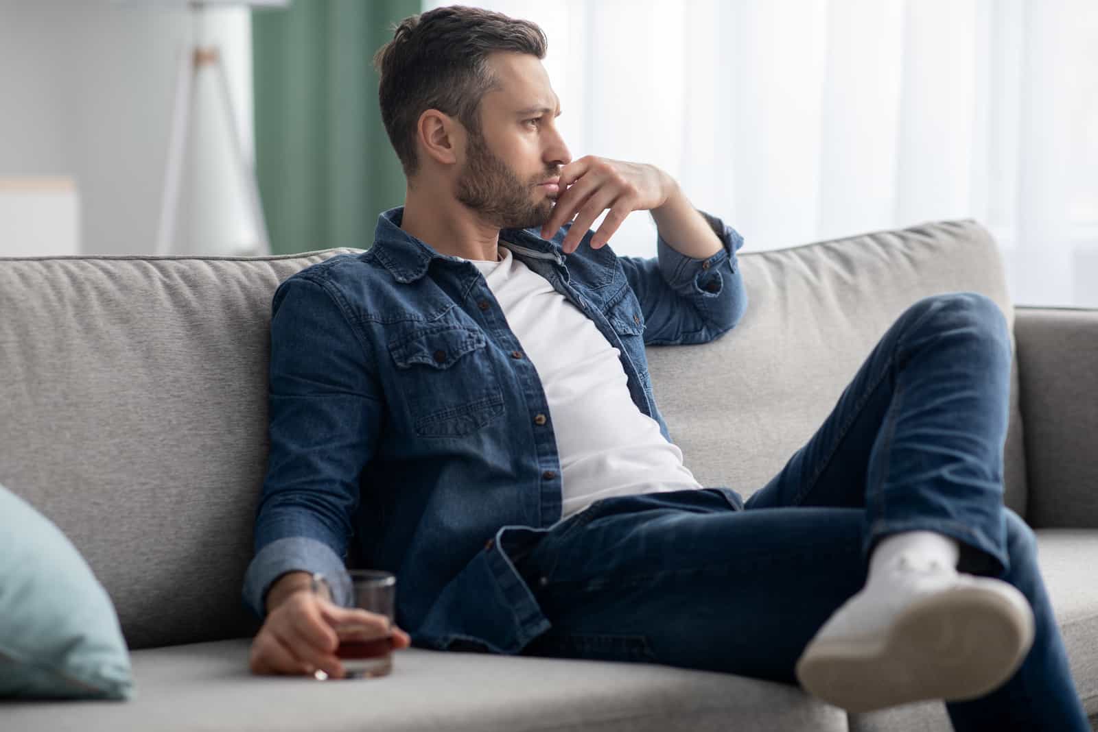 Mann sitzt am Sofa