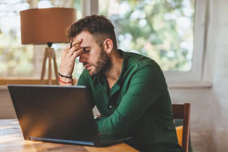 gestresster Mann vor Laptop