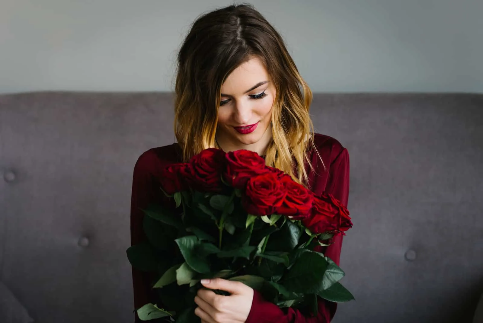 junge Frau hält einen Strauß roter Rosen