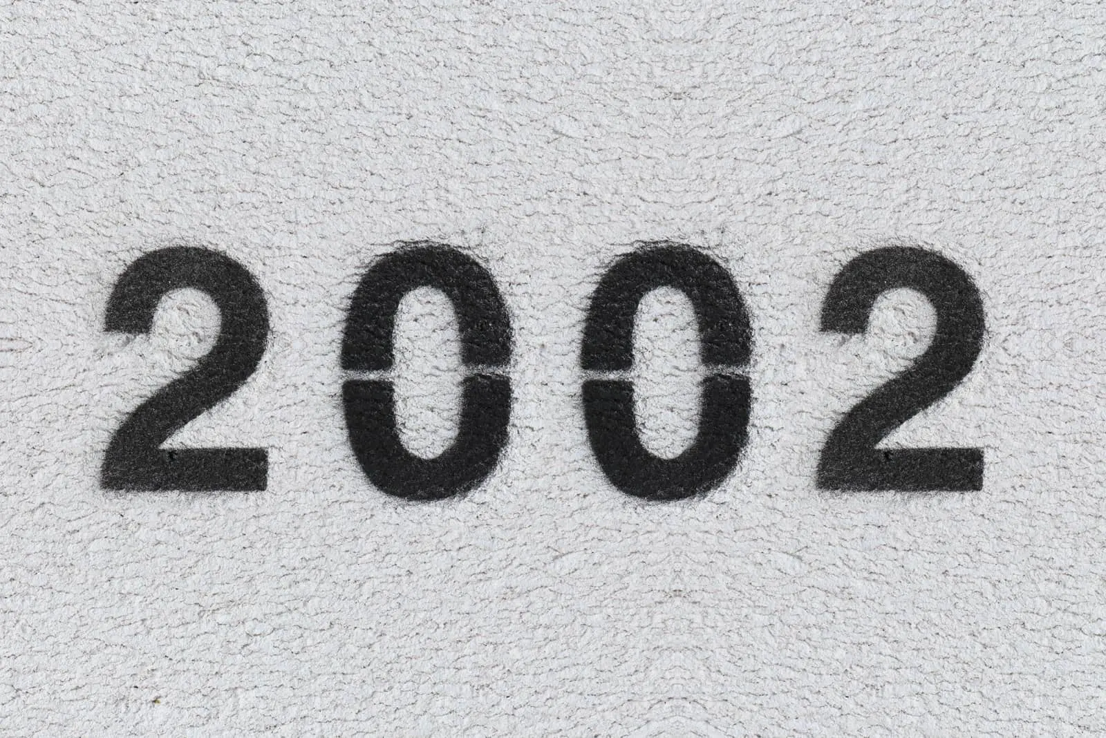 schwarze Zahl 2002 auf grauer Wand