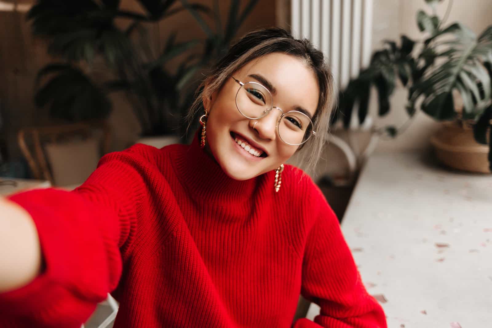 Frau im roten Pullover macht Selfie