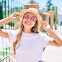 glückliche junge Frau mit pinkfarbener Sonnenbrille an einem sonnigen Tag