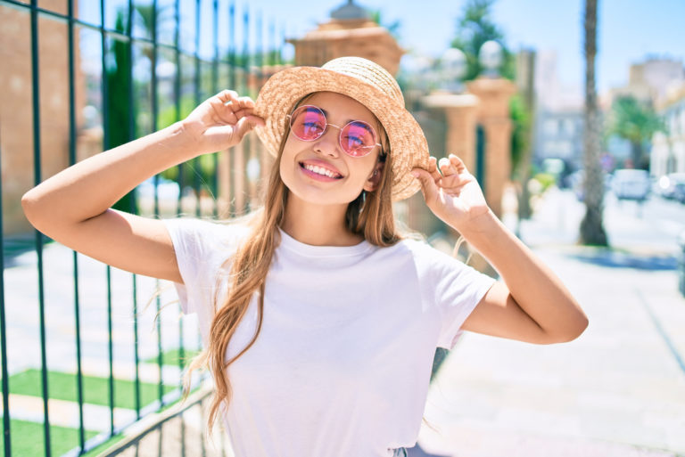 glückliche junge Frau mit pinkfarbener Sonnenbrille an einem sonnigen Tag