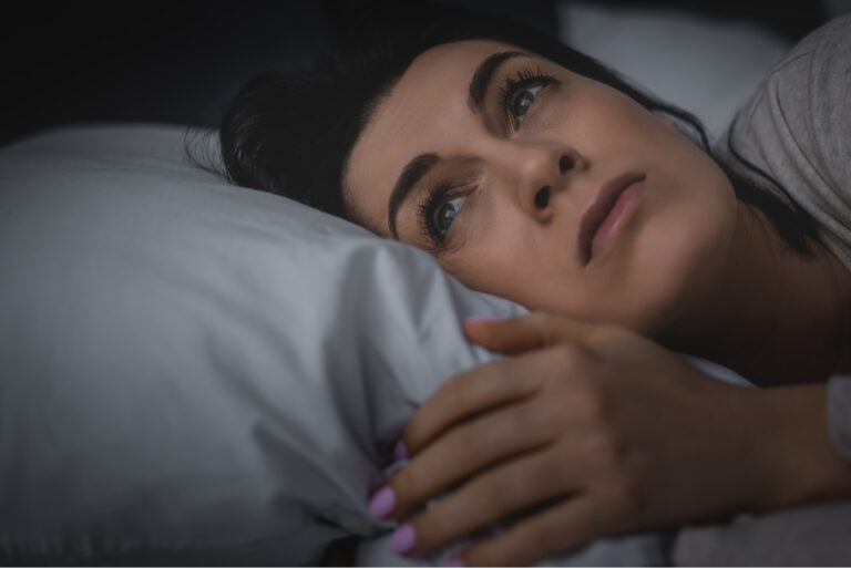 Die Frau liegt wach im Bett