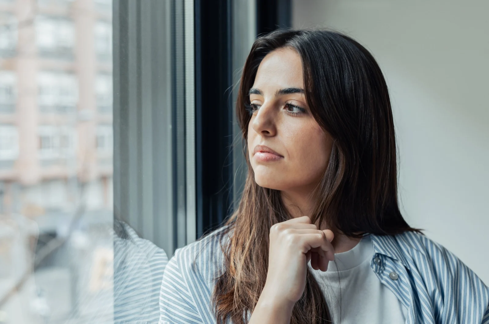 Traurige Frau, die durch das Fenster schaut