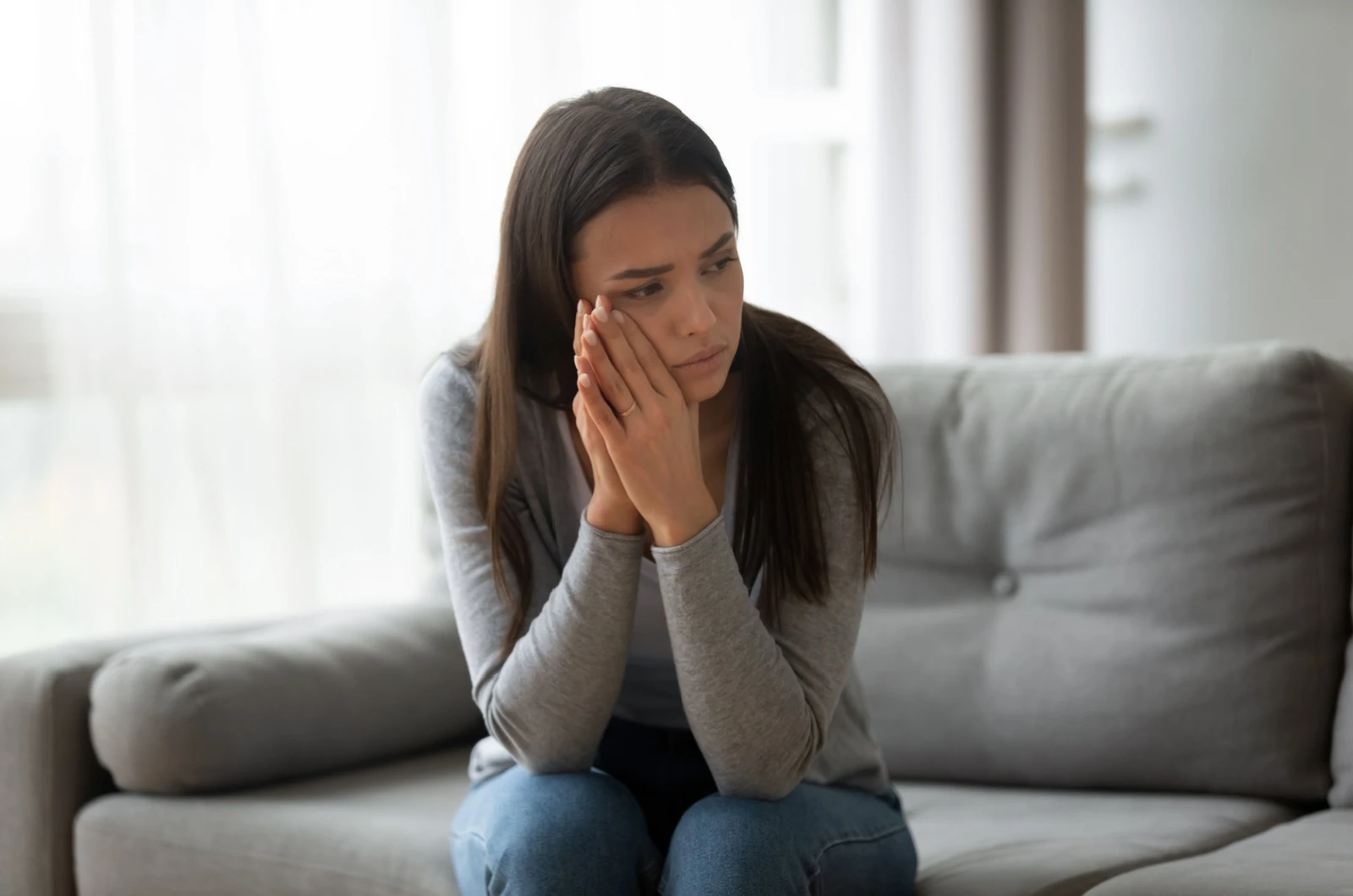 traurige Frau sitzt auf der Couch