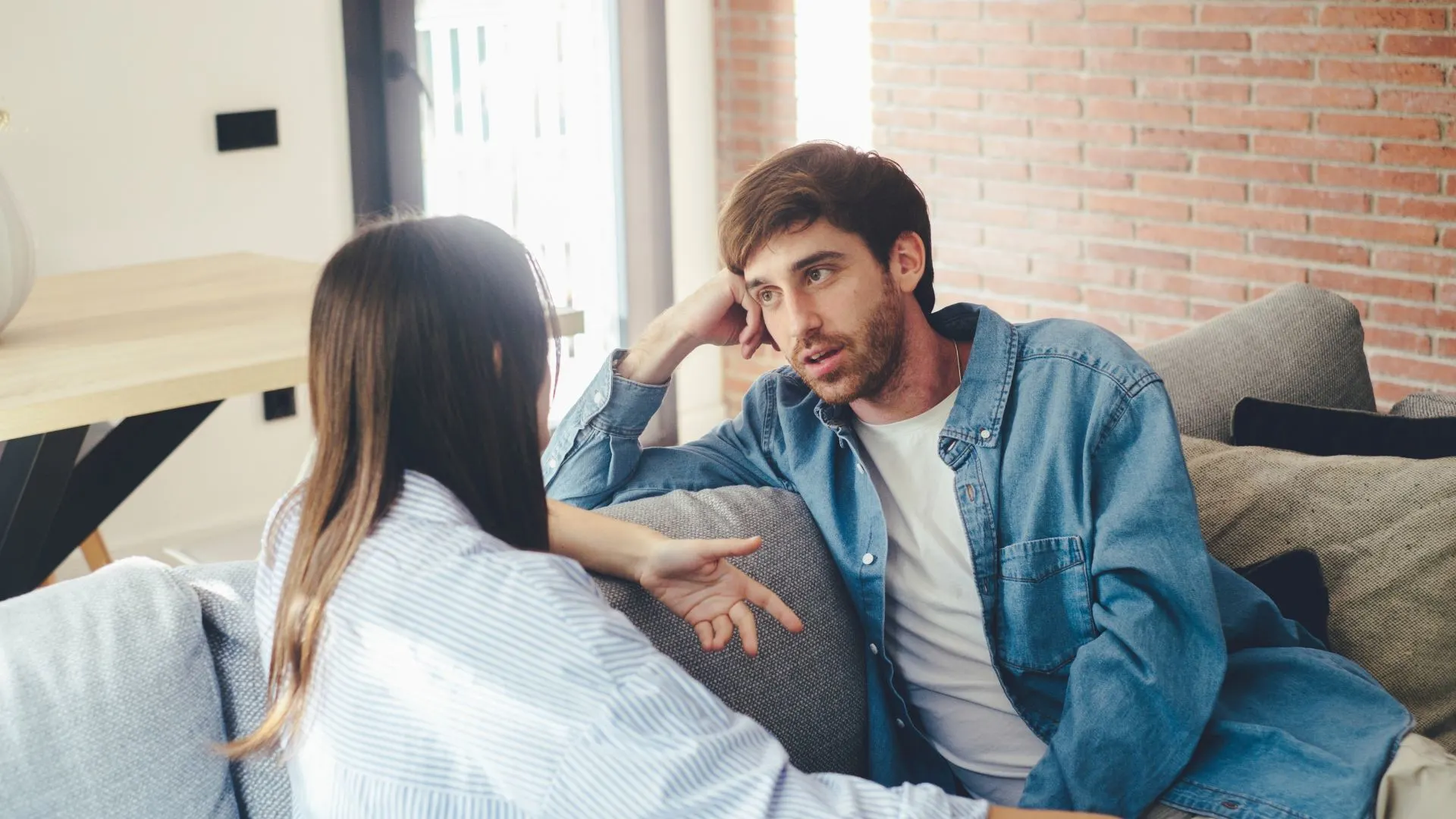Ein Mann und eine Frau sitzen auf einer Couch und unterhalten sich