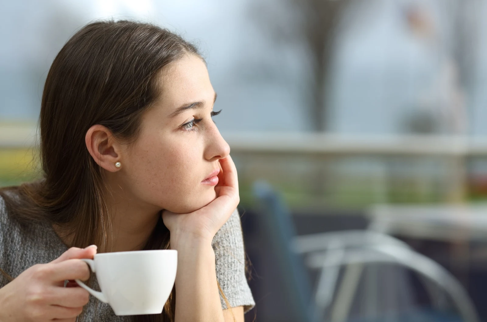 traurige Frau mit Tasse in der Hand