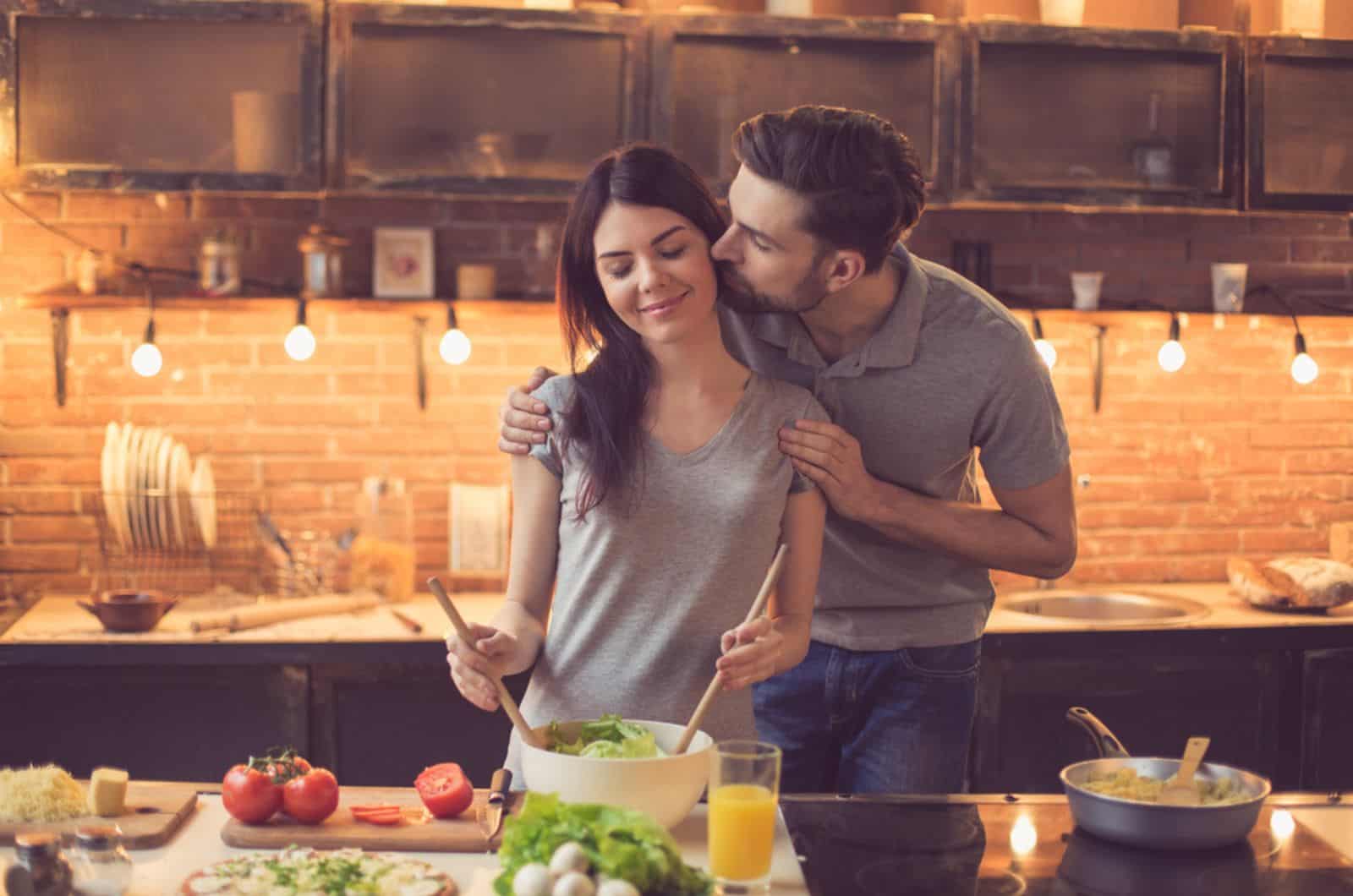 Mann küsst seine Frau in der Küche